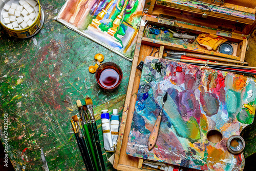 Colorful workplace of the artist with brushes and oil paints