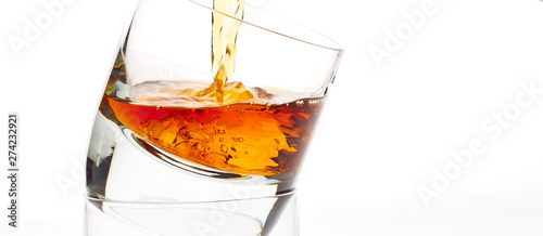 pouring whisky in glass of whisky and ice cubes