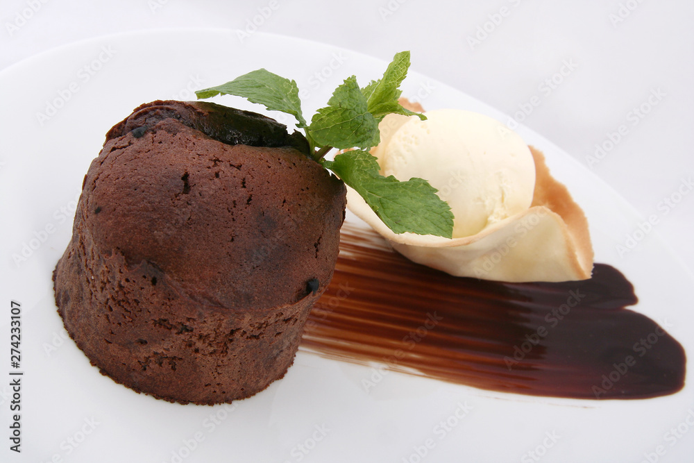 chocolate muffin and ice cream ball. beautifully served on a white plate. on a white background chocolate muffin and ice cream ball. beautifully served on a white plate. on a white background