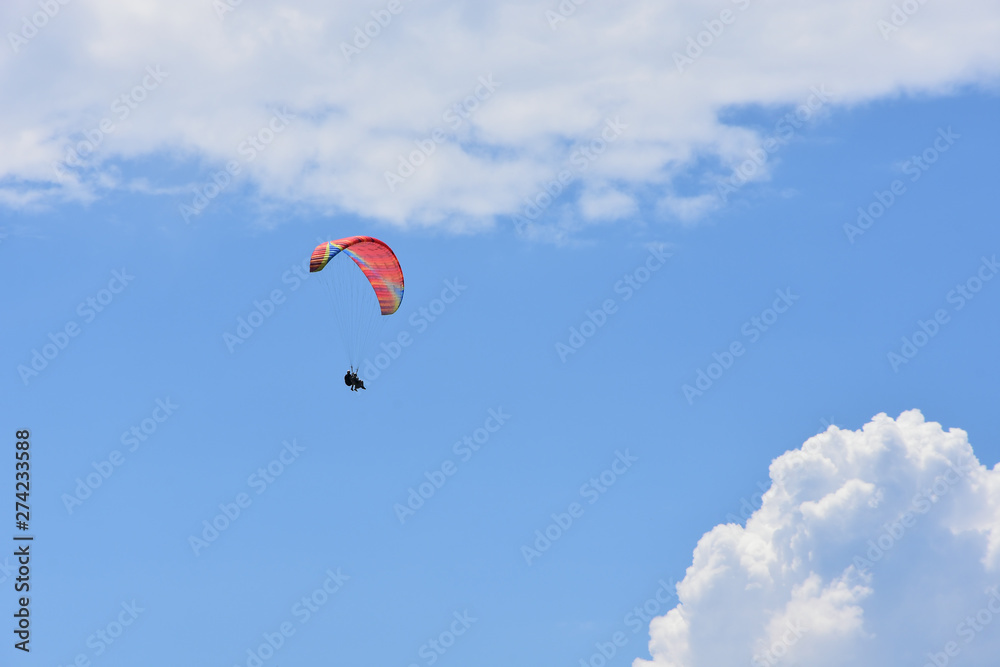 Red ram-air tandem paraglider flying high in blue sky with white cirrous  clouds Stock Photo | Adobe Stock