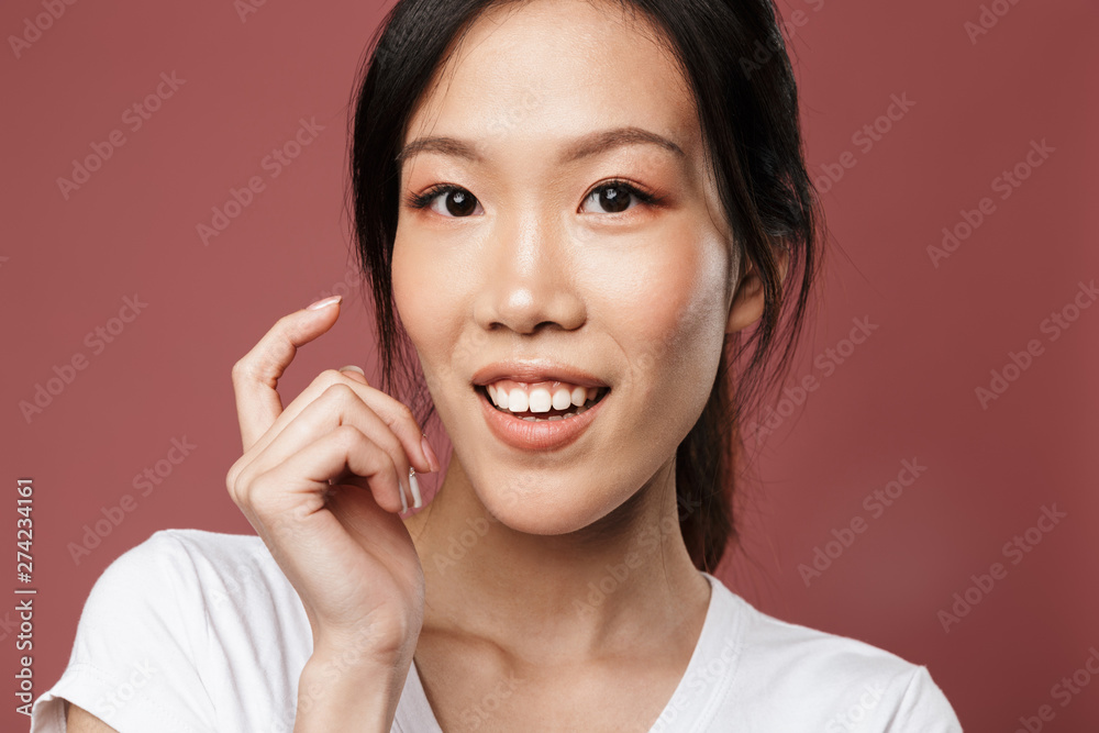 Portrait of attractive asian woman dressed in basic wear smiling and looking at camera Portrait of attractive asian woman dressed in basic wear smiling and looking at camera