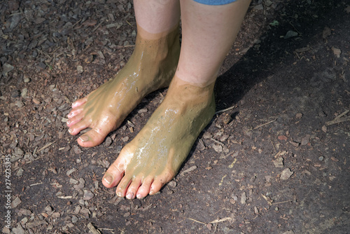 Female bare feet in the mud