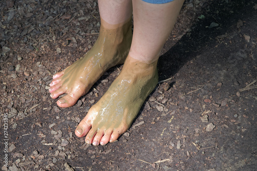 Female bare feet in the mud photo