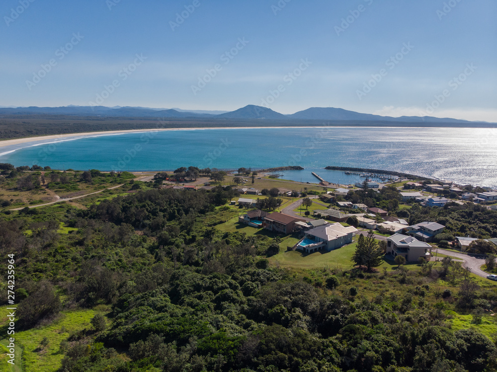 Drone picture of a huge beach forest and a small city in Australia