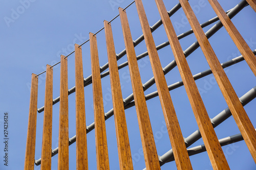 Modern architectural construction of wooden slats with half-round, openwork design