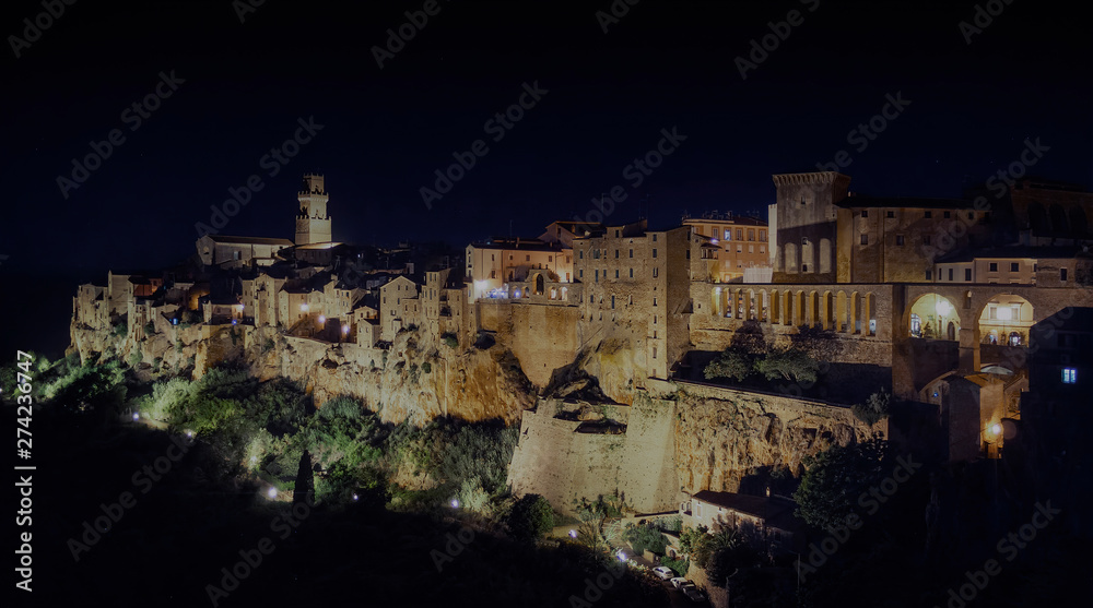 PITIGLIANO, TUSCANY, ITALY - JUNE 2019 - View of Pitigliano town late evening. Picturesque and unusual - built on tuff, tufaceous volcanic rock. PITIGLIANO, TUSCANY, ITALY - JUNE 2019 - View of Pitigliano town late evening. Picturesque and unusual - built on tuff, tufaceous volcanic rock.