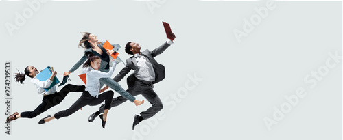 Happy office workers jumping and dancing in casual clothes or suit with folders isolated on studio background. Business  start-up  working open-space  motion and action concept. Creative collage.