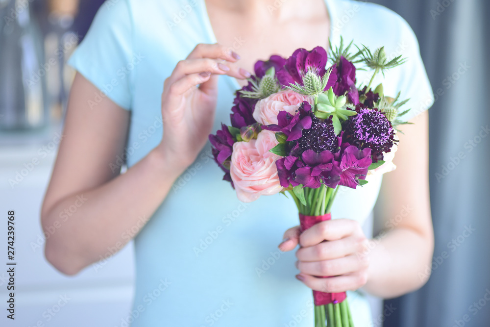 Selective focus on flowers, the girl florist's figure is blurred. Floristic workshop. Selective focus on flowers, the girl florist's figure is blurred. Floristic workshop.