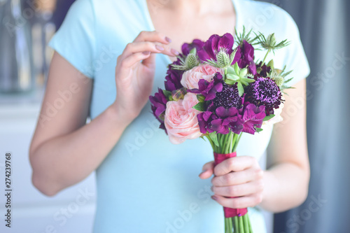 Selective focus on flowers, the girl florist's figure is blurred. Floristic workshop.