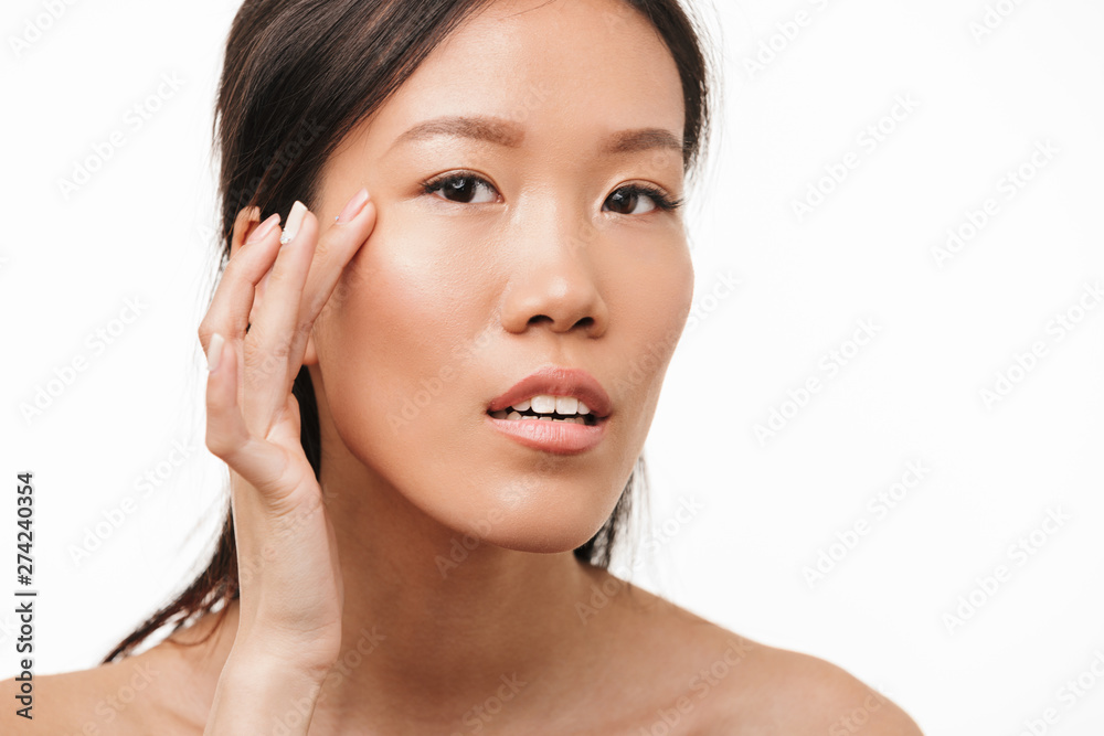 Beautiful positive asian young pretty woman with healthy skin posing isolated over white wall background.