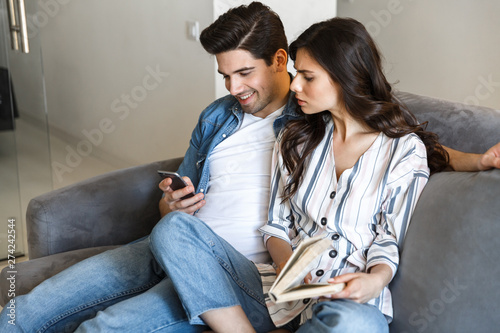 Attractive young couple relaxing on a couch at home