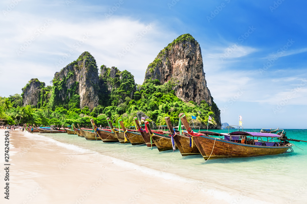 Thai traditional wooden longtail boats and beautiful sand beach.