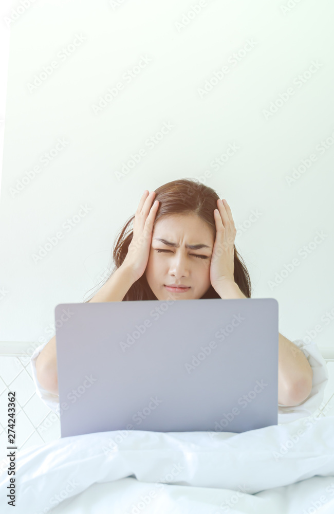 Women have headaches. And stressed from work.In the white room there is a lady inside.Do not focus on the main object of this image. Women have headaches. And stressed from work.In the white room there is a lady inside.Do not focus on the main object of this image.