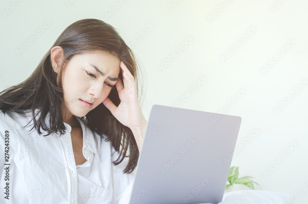 Women have headaches. And stressed from work.In the white room there is a lady inside.Do not focus on the main object of this image. Women have headaches. And stressed from work.In the white room there is a lady inside.Do not focus on the main object of this image.