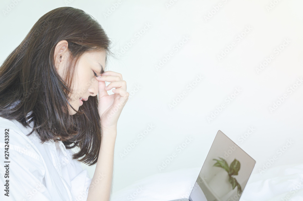 Women have headaches. And stressed from work.In the white room there is a lady inside.Do not focus on the main object of this image. Women have headaches. And stressed from work.In the white room there is a lady inside.Do not focus on the main object of this image.