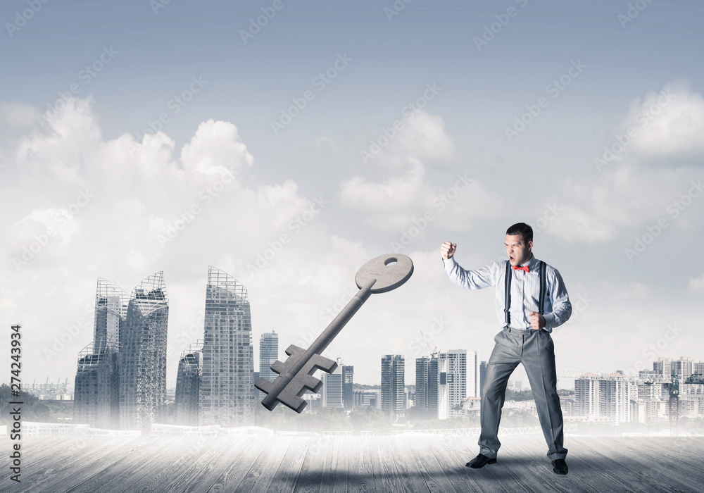 Breaking through access concept with furious man crashing concrete key Breaking through access concept with furious man crashing concrete key