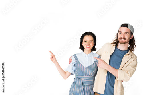 young couple pointing with fingers, hugging and looking at camera isolated on white