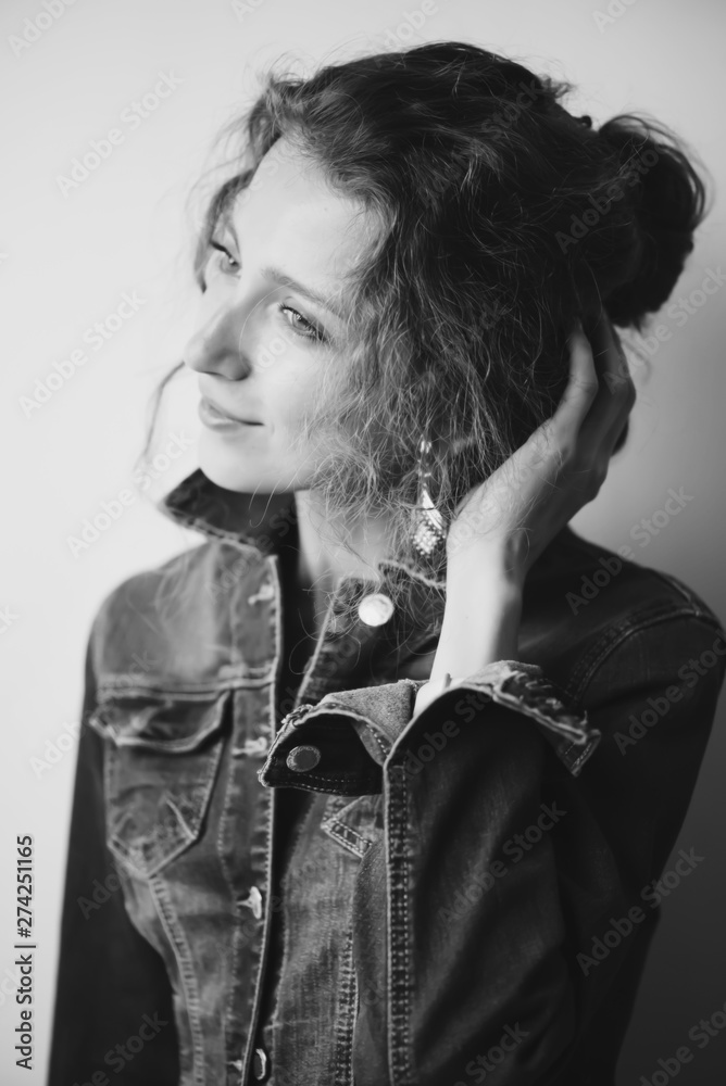 stylish pretty curly girl in a denim jacket