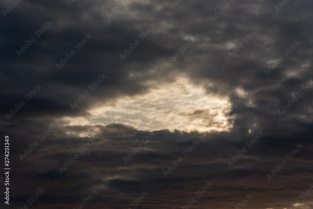 Dark Cloudscape at Sunset with a Hole in the Sky
