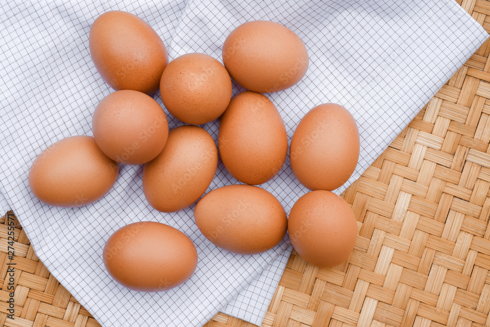 Brown eggs lay on a white plaid fabric. Healthy food concepts. Brown eggs lay on a white plaid fabric. Healthy food concepts.