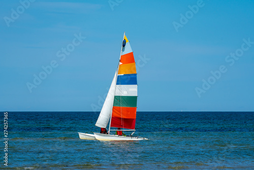 catamaran sailing boat with a very colourful sail