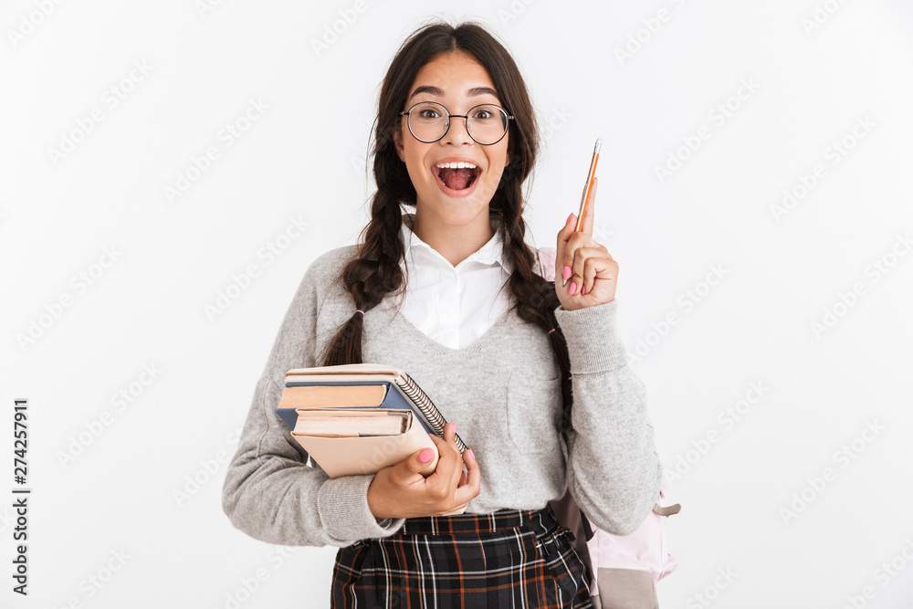 Photo closeup of surprised teenage girl wearing eyeglasses thinking while holding studying books and pen Photo closeup of surprised teenage girl wearing eyeglasses thinking while holding studying books and pen