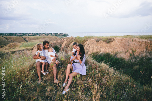 Happy dad and children having fun outdoors in a wheat field. landscape