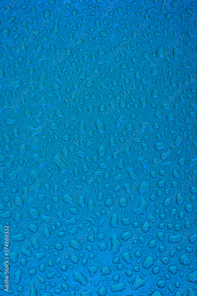 Fototapeta premium Small liquid drops on a blue background