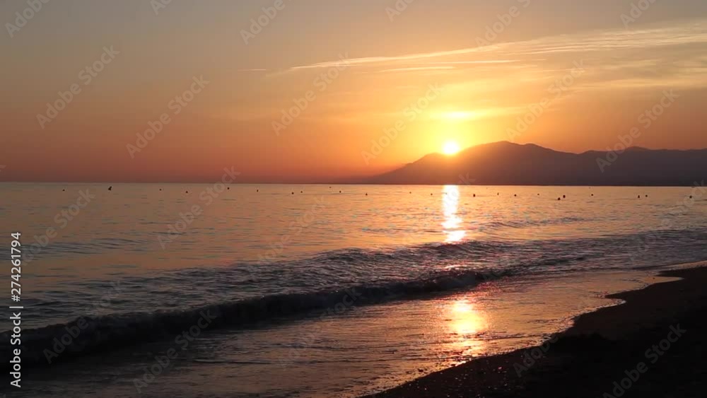 Dark orange sunset in Marbella beach, Málaga, Spain. Mediterranean sea waves, sun path reflection. Dark orange sunset in Marbella beach, Málaga, Spain. Mediterranean sea waves, sun path reflection.
