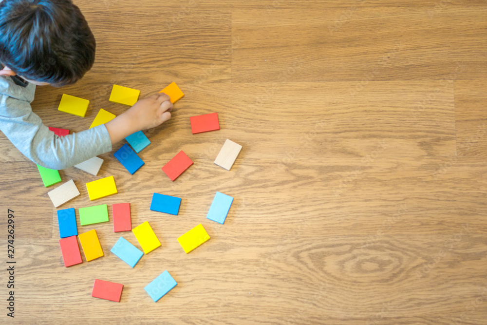 child playing with colorful wooden pieces