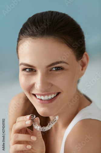 Dental care. Smiling woman with white smile using whitening tray
