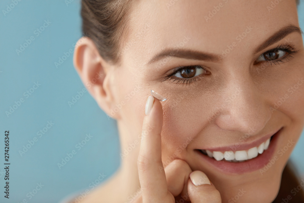 Eye care. Smiling woman with contact eye lens on finger closeup Eye care. Smiling woman with contact eye lens on finger closeup