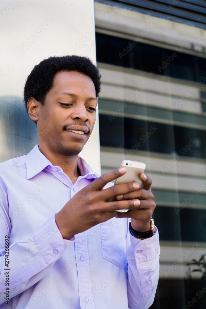 Latin businessman using mobile phone in the city. Latin businessman using mobile phone in the city.