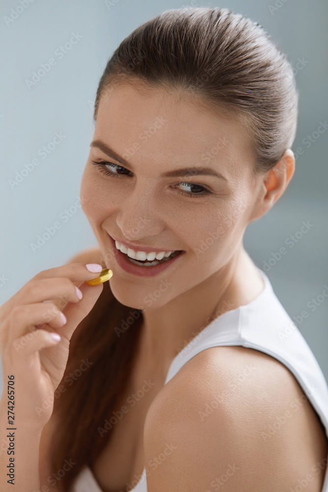 Vitamin. Smiling woman taking omega pill, fish oil supplement Vitamin. Smiling woman taking omega pill, fish oil supplement
