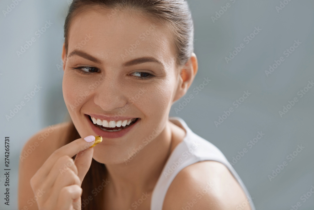 Vitamin. Smiling woman taking omega pill, fish oil supplement Vitamin. Smiling woman taking omega pill, fish oil supplement