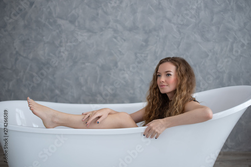 Smiling woman relaxing in bathtub