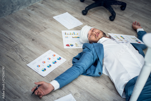 Business man in suits lying unconscious on the floor in the office