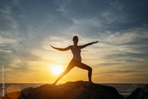Fototapeta Naklejka Na Ścianę i Meble -  Silhouette of a woman yoga on sea sunset.