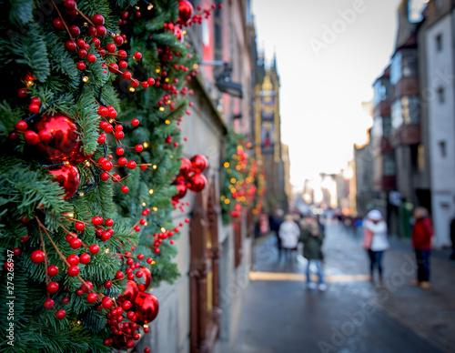 Christmas tree decorated on the wall with red balls. Blurred street in the background 