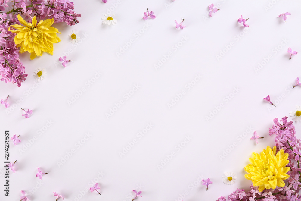 Feminine frame background made of various flowers with a lot of copy space for text. Close up, top view, flat lay.