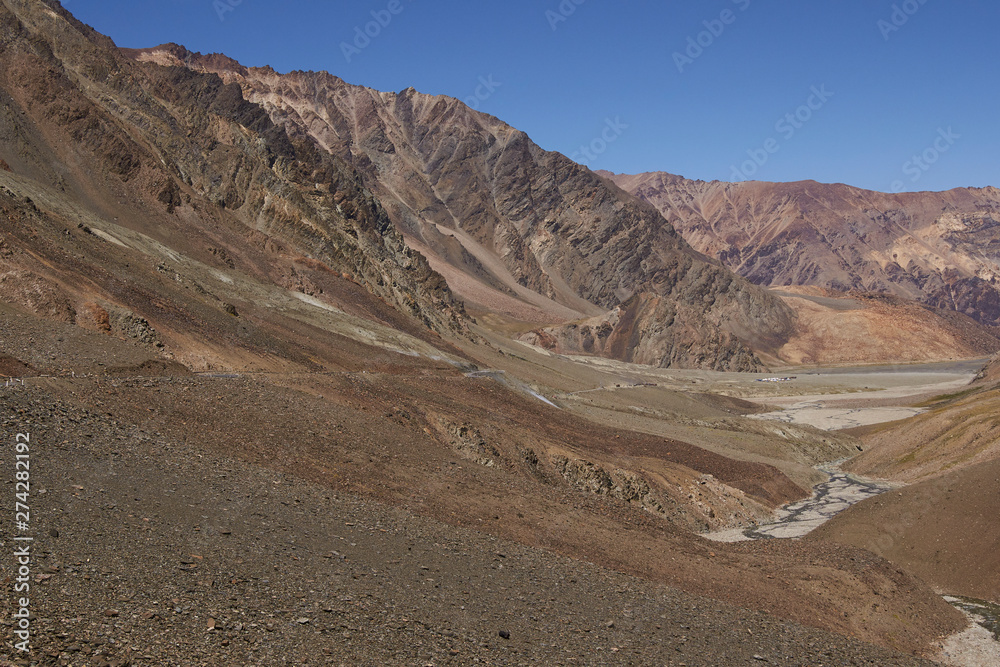 Manali to Leh mountain highway in India. Winding road running through barren snow peaked mountains. Manali to Leh mountain highway in India. Winding road running through barren snow peaked mountains.