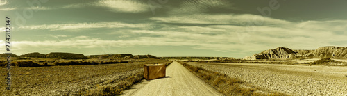 Strasse in einer Wüstenlandschaft mit Koffer