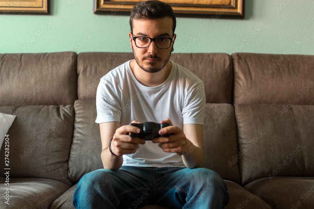 Young man playing video game holding wireless controller Young man playing video game holding wireless controller