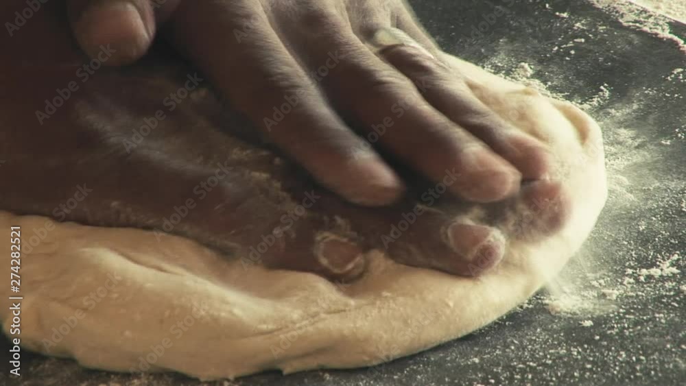 LOCKED OFF CLOSE UP view of Male hands kneading dough on wooden board LOCKED OFF CLOSE UP view of Male hands kneading dough on wooden board