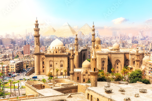 The Mosque-Madrassa of Sultan Hassan and the Pyramids on the background, beautiful view of Cairo, Egypt