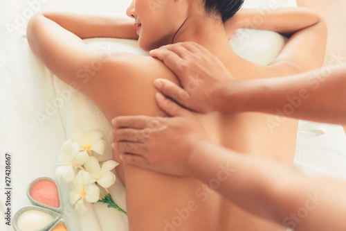 hands of Masseuse or service provider doing shoulder massage with Young Asian woman enjoying Oil spa massage in spa salon at hotel or resort. Beauty lifestyle and people concept