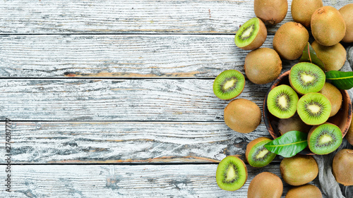 Fresh kiwi on a white wooden table. Rustic style. Fruits. Top view. Free space for text.