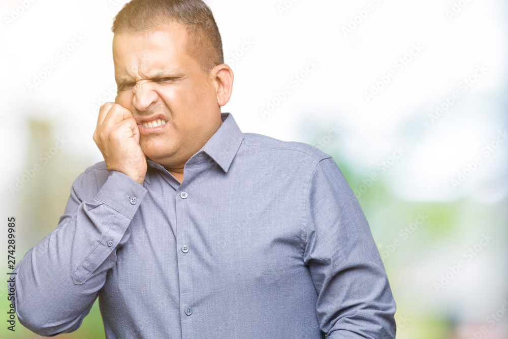 Middle age arab business man over isolated background looking stressed and nervous with hands on mouth biting nails. Anxiety problem. Middle age arab business man over isolated background looking stressed and nervous with hands on mouth biting nails. Anxiety problem.