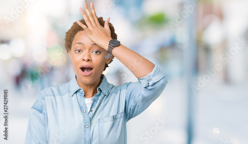 Young beautiful african american woman over isolated background surprised with hand on head for mistake, remember error. Forgot, bad memory concept.