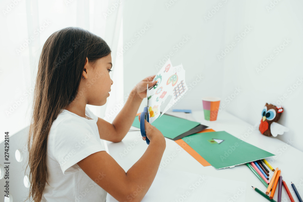 The girl cutting out of paper various pictures, children's leisure craft work The girl cutting out of paper various pictures, children's leisure craft work